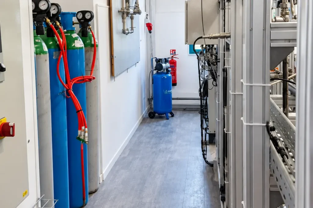 Couloir du laboratoire pilote de Plenesys, avec des bouteilles de gaz