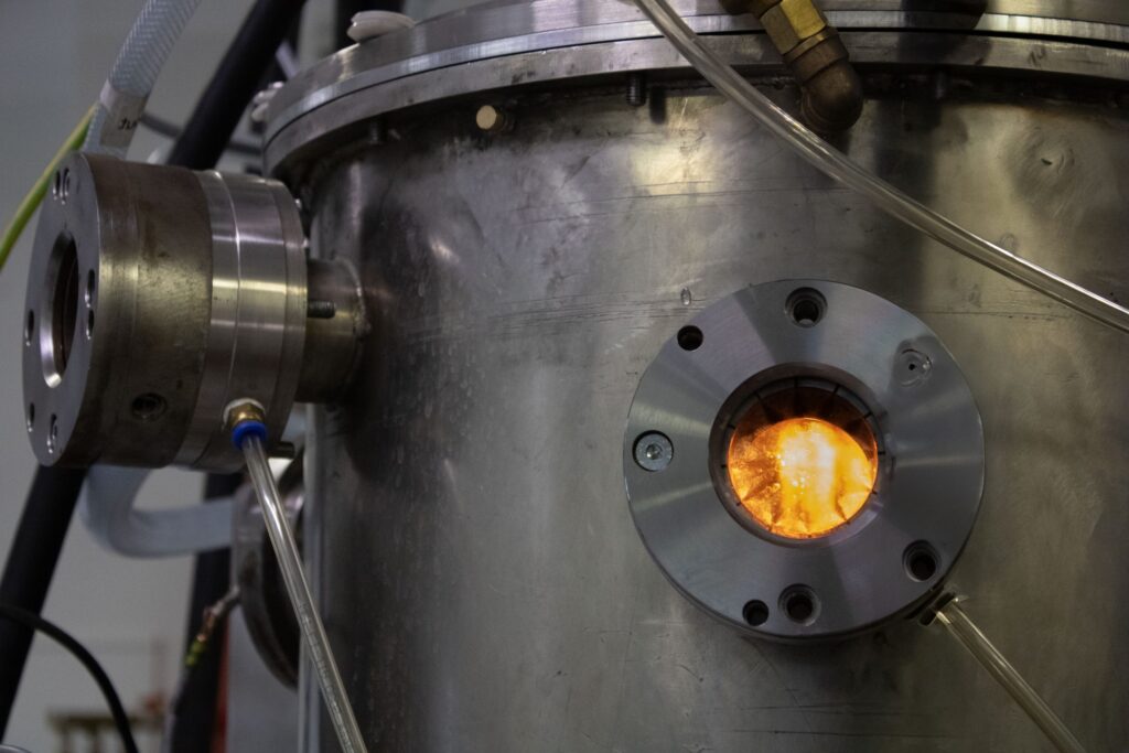 Lueur orange de l’arc plasma Plenesys vue à travers le hublot du réacteur