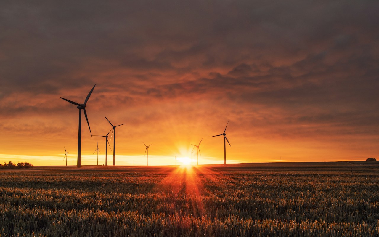 Éoliennes au coucher du soleil au-dessus d’un champ